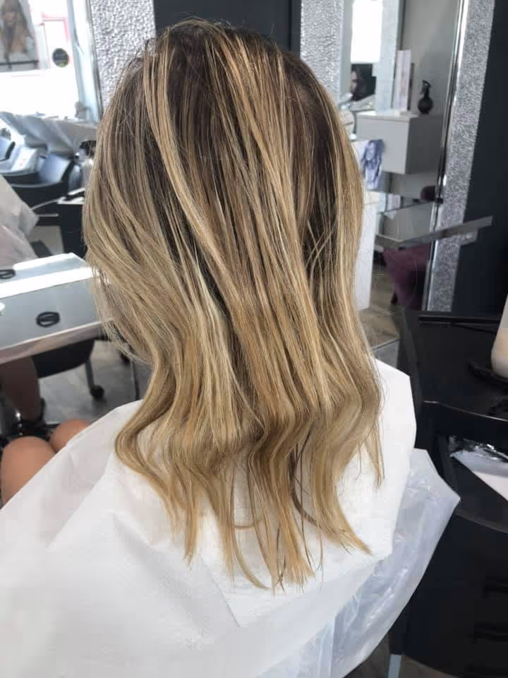 Balayage blond sur racines foncées, longueurs ondulées