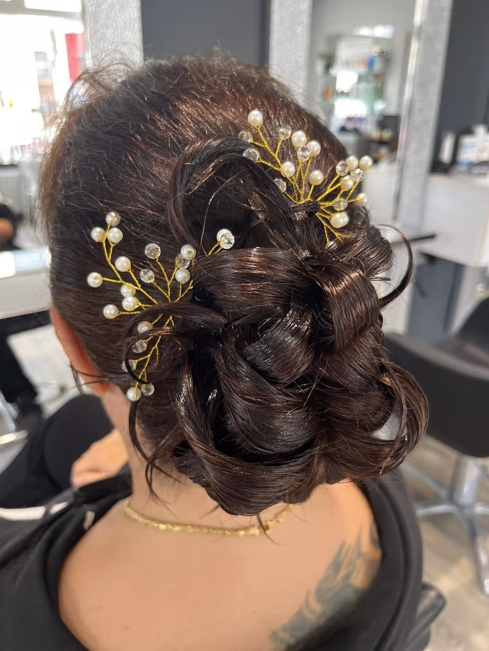 Chignon de mariée relevé, orné d'épingles à perles et de bijoux dorés